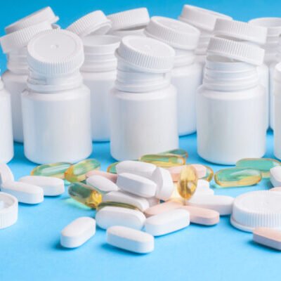 Many pills and tablets isolated on light blue background Many pills and tablets isolated on light blue background. Pharmaceutical medicament, cure in container for health. Antibiotic, painkiller closeup. Copy space for text.Many pills and tablets isolated on light blue background. Pharmaceutical medicament, cure in container for health. Antibiotic, painkiller closeup. Copy space for text.